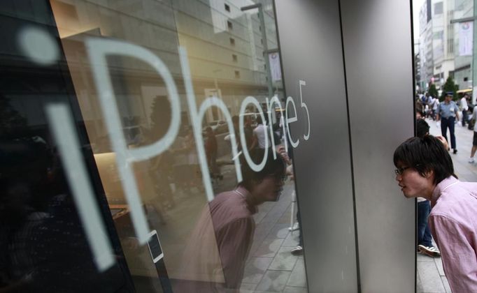 A man peeks inside an Apple Store ahead of sales of Apple Inc's iPhone 5 in Tokyo September 21, 2012. Apple Inc's iPhone 5 hit stores around the globe on Friday, with fans snapping up the device that is expected to fuel a huge holiday quarter for the consumer giant. REUTERS/Yuriko Nakao (JAPAN - Tags: BUSINESS SCIENCE TECHNOLOGY) Published: Zář. 21, 2012, 1:45 dop.