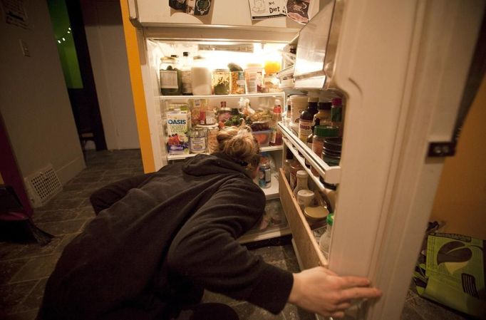 Anna-Rae Douglass, 23, a pracitsing 'freegan', looks through her fridge of scavenged food at her house in Vancouver, British Columbia April 10, 2012. A 'Freegan' is someone who gathers edible food from the garbage bins of grocery stores or food stands that would otherwise have been thrown away. Freegans aim to spend little or no money purchasing food and other goods, not through financial need but to try to address issues of over-consumption and excess. Picture taken April 10, 2012. REUTERS/Ben Nelms (CANADA - Tags: SOCIETY) ATTENTION EDITORS PICTURE 08 OF 21 FOR PACKAGE 'DUMPSTER DIVING FOR FOOD' Published: Kvě. 15, 2012, 11:58 dop