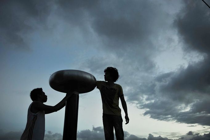 Performing With Lightning CHANGLE, CHINA - AUGUST 12: (CHINA OUT) Wang Zengxiang and his friends install a Tesla coil transformer prior to a stunt performance on August 12, 2012 in Changle, Fujian Province of China. Wang Zengxiang, one of the craziest fans of the Tesla coil stunt, has dedicated himself in the daredevil career for a decade. He is now the leader of a band of four. A Tesla coil is an electrical resonant transformer circuit invented by Nikola Tesla around 1891. The transformer produces high voltage at high frequencies, which acts as a giant lightning machine, and creates long bolts of electricity. Shielded by protective clothing, the performer is insulated from the electricity current which dissipates through the ground. ( automatický překlad do češtiny )