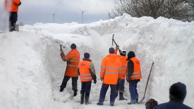 Skupina se prokousává s krumpáči v rukou obří návějí kdesi v okolí Měděnce.