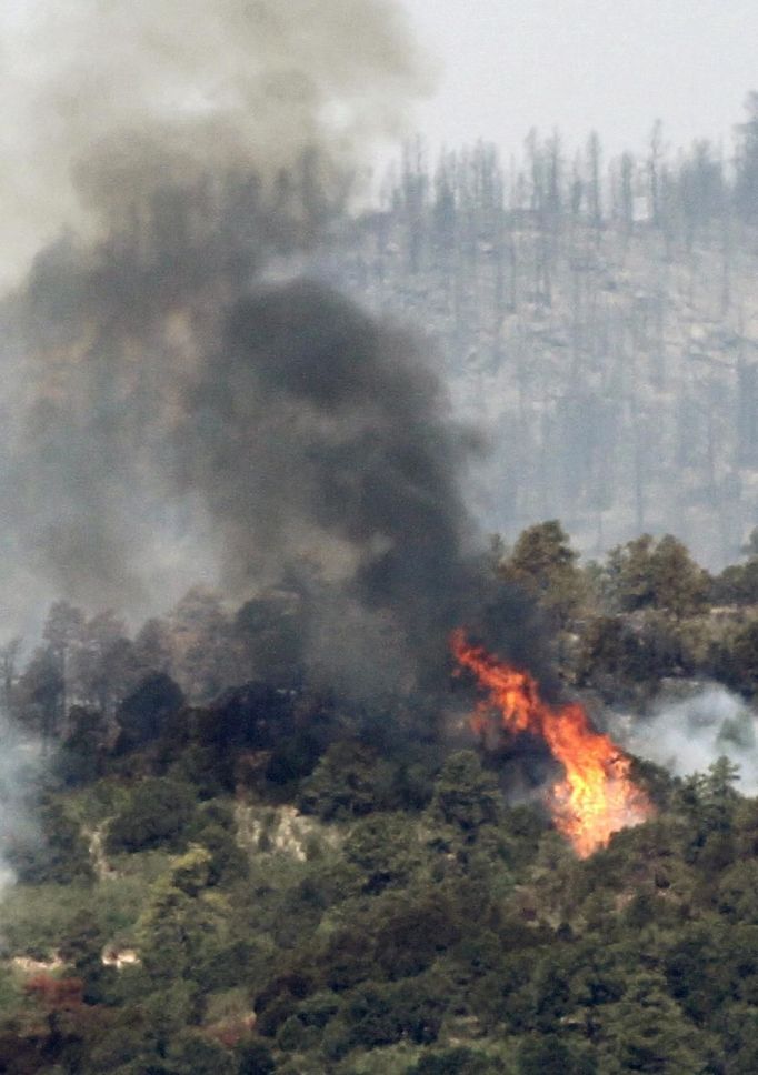 Fire continues to burn in the Cedar Heights subdivision in the Waldo Canyon fire west of Colorado Springs, Colorado June 25, 2012. A fast-growing wildfire in Colorado forced 11,000 people from their homes at least briefly and threatened popular summer camping grounds beneath Pikes Peak, whose vistas helped inspire the patriotic tune "America the Beautiful." REUTERS/Rick Wilking (UNITED STATES - Tags: DISASTER) Published: Čer. 25, 2012, 6:07 odp.