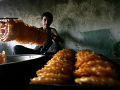 Prodavač cukroví a sladkostí čeká na zákazníky v Kábulu.