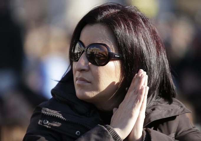 A woman waits in a packed Saint Peter's Square where Pope Benedict XVI holds his last general audience, at the Vatican February 27, 2013. The weekly event which would normally be held in a vast auditorium in winter, but has been moved outdoors to St. Peter's Square so more people can attend. The pope has two days left before he takes the historic step of becoming the first pontiff in some six centuries to step down instead of ruling for life. REUTERS/Alesandro Bianchi (VATICAN - Tags: RELIGION SOCIETY) Published: Úno. 27, 2013, 10:08 dop.