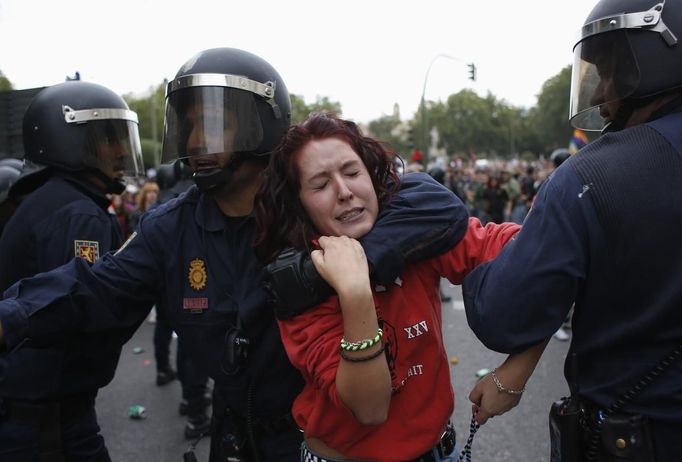 A protester is dragged away by a police officer after the police charged demonstrators outside Spanish parliament in Madrid, September 25, 2012. Protesters clashed with police in Spain's capital on Tuesday as the government prepares a new round of unpopular austerity measures for the 2013 budget that will be announced on Thursday. REUTERS/Susana Vera (SPAIN - Tags: CIVIL UNREST POLITICS) Published: Zář. 25, 2012, 7:54 odp.