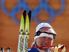 Kristina Šmigunová se zlatou medailí ve skiatlonu.