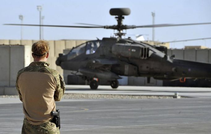 Britain's Prince Harry watches an Apache helicopter return from a mission, at Camp Bastion, southern Afghanistan in this photograph taken November 3, 2012, and released January 21, 2013. The Prince, who is serving as a pilot/gunner with 662 Squadron Army Air Corps, is on a posting to Afghanistan that runs from September 2012 to January 2013. Photograph taken November 3, 2012. REUTERS/John Stillwell/Pool (AFGHANISTAN - Tags: MILITARY POLITICS SOCIETY MEDIA ROYALS CONFLICT) Published: Led. 21, 2013, 7:54 odp.