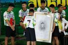Thajští fotbalisté a jejich trenér (vlevo) uctili krátce po svém vysvobození Samana Gunana, který zemřel během záchranné akce.