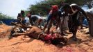 People slaughter a cow on the first day of Eid al-Adha in Somalia's capital Mogadishu, October 26, 2012. Muslims around the world celebrate Eid al-Adha to mark the end of the Haj by slaughtering sheep, goats, cows and camels to commemorate Prophet Abraham's willingness to sacrifice his son Ismail on God's command. REUTERS/Omar Faruk (SOMALIA - Tags: SOCIETY RELIGION ANIMALS) TEMPLATE OUT Published: Říj. 26, 2012, 4:10 odp.