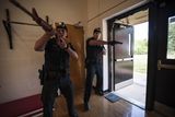 Policisté po obdržení telefonátu, který nahlašuje střelbu na střední škole, bleskurychle dorážejí se zbraní v ruce.