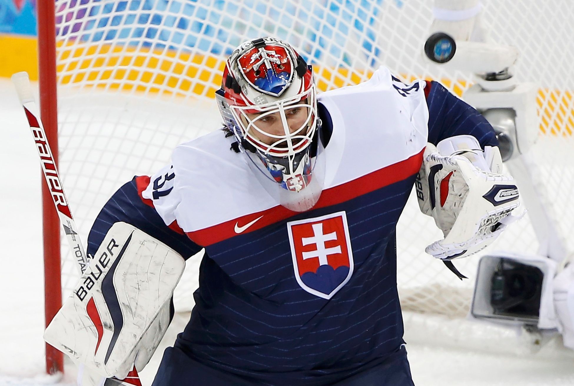Slovakia's goalie Peter Budaj makes a save against Team USA during their men's preliminary round ice hockey game at the 2014 Sochi Winter Olympics