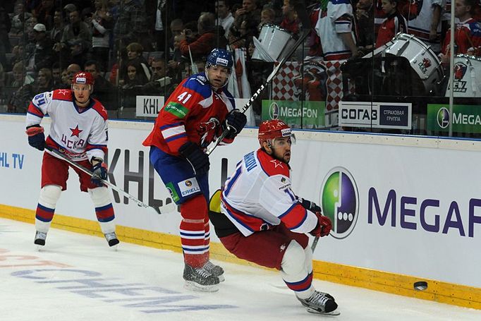 Hokejista Lva Praha Martin Škoula odehrává puk před Michailem Grabovským (vlevo) a Vladimirem Žarkovem v utkání KHL proti CSKA Moskva.