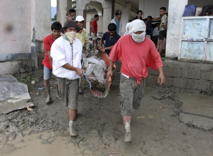 Rescuers carry a flash flood victim after Typhoon Bopha hit New Bataan in Compostela province, southern Philippines December 5, 2012. Bopha, the Philippines' strongest typhoon this year, was headed towards tourist destinations on Wednesday after hitting a southern island, destroying homes, causing landslides and killing at least 82 people, but many more are reported dead and missing. REUTERS/Stringer(PHILIPPINES - Tags: DISASTER ENVIRONMENT) Published: Pro. 5, 2012, 6:04 dop.