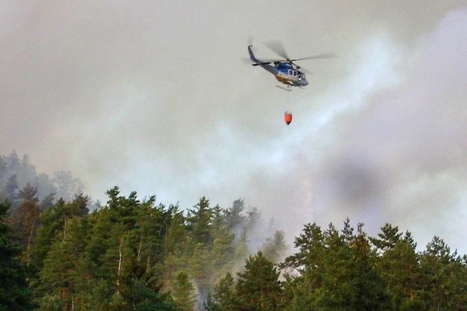 Policejní vrtulník během nasazení při hašení požáru v NP České Švýcarsko. 27. 7. 2022