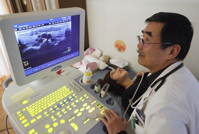 A doctor at a clinic in temporary housing complex Shunji Sekine conducts a thyroid examination on a woman in Nihonmatsu, about 50 km (31 miles) from the tsunami-crippled Fukushima Daiichi nuclear power plant, Fukushima prefecture February 25, 2013, ahead of the second-year anniversary of the March 11, 2011 earthquake and tsunami. As the World Health Organisation (WHO) says children in Fukushima may have a higher risk of developing thyroid cancer after the Daiichi nuclear disaster two years ago, mothers in Fukushima worry that local health authorities are not doing enough. Picture taken February 25, 2013. REUTERS/Chris Meyers (JAPAN - Tags: DISASTER HEALTH) Published: Úno. 28, 2013, 2:53 odp.