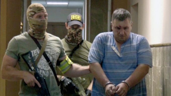 Jevgenij Panov, údajný ukrajinský záškodník na Krymu, v doprovodu příslušníků ruské FSB.