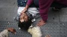 A protester lies injured on the ground after riot police charged demonstrators outside the Spanish parliament in Madrid, September 25, 2012. Protesters clashed with police in Spain's capital on Tuesday as the government prepares a new round of unpopular austerity measures for the 2013 budget that will be announced on Thursday. REUTERS/Susana Vera (SPAIN - Tags: CIVIL UNREST POLITICS BUSINESS) Published: Zář. 25, 2012, 9:03 odp.