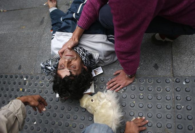 A protester lies injured on the ground after riot police charged demonstrators outside the Spanish parliament in Madrid, September 25, 2012. Protesters clashed with police in Spain's capital on Tuesday as the government prepares a new round of unpopular austerity measures for the 2013 budget that will be announced on Thursday. REUTERS/Susana Vera (SPAIN - Tags: CIVIL UNREST POLITICS BUSINESS) Published: Zář. 25, 2012, 9:03 odp.