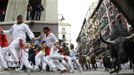 A Fuente Ymbro fighting bull slides towards the fence as runners sprint alongside at the Estafeta corner during the fifth running of the bulls of the San Fermin festival in Pamplona July 11, 2012. Several runners suffered light injuries in a run that lasted three minutes and twelve seconds, according to local media. REUTERS/Susana Vera (SPAIN - Tags: SOCIETY ANIMALS) Published: Čec. 11, 2012, 8:49 dop.