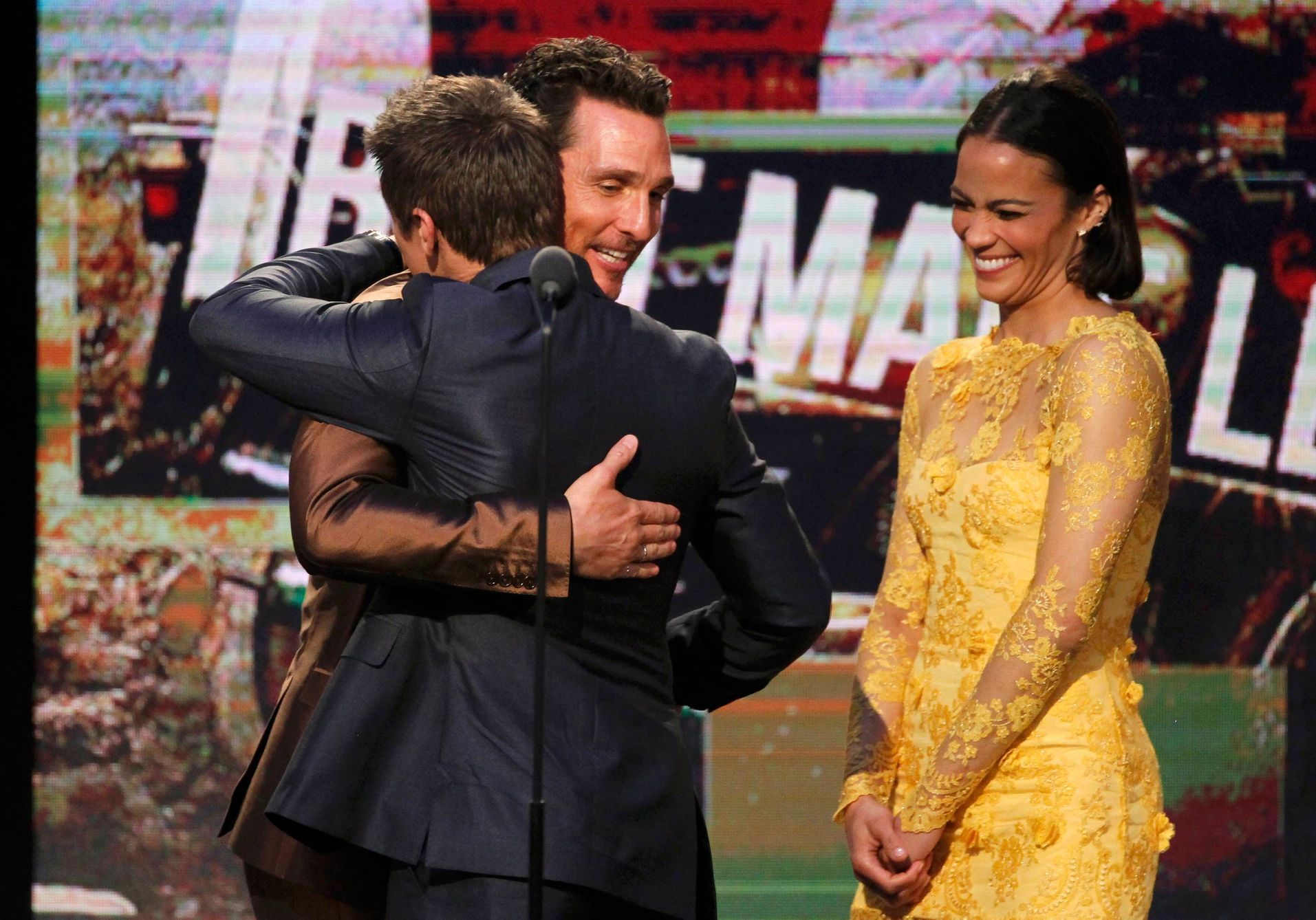 Matthew McConaughey, best male lead winner for his role in &quot;Dallas Buyers Club&quot;(2nd L) hugs presenter Jeremy Renner (L) as presenter Paula Patton looks on as he accepts his award at the 2014