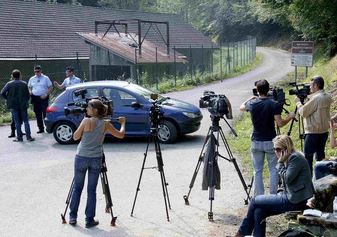 ATTENTION EDITORS - FRENCH LAW REQUIRES THAT FACES OF LAW ENFORCEMENT OFFICERS ARE MASKED IN PUBLICATIONS WITHIN FRANCE Members of the media gather next to a blocked road in Chevaline near Annecy, southeastern France, September 6, 2012. French police have found a girl of about four years old alive inside a British-registered BMW car where they discovered three people shot dead on Wednesday, September 5, a public prosecutor said. A fourth body, apparently a person who had been riding a bicycle, was found nearby. A badly injured eight-year-old girl, also found nearby, was taken to hospital by helicopter. REUTERS/Robert Pratta (FRANCE - Tags: CRIME LAW) Published: Zář. 6, 2012, 10:27 dop.