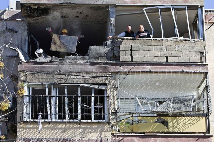 An Israeli soldier throws a blood-stained table out of a building damaged by a rocket, fired from Gaza, in the southern city of Kiryat Malachi November 15, 2012. A Hamas rocket killed three Israelis north of the Gaza Strip on Thursday, drawing first blood from Israel as the Palestinian death toll rose to 13 and the military showdown lurched closer to all-out war. REUTERS/Nir Elias (ISRAEL - Tags: CIVIL UNREST MILITARY) Published: Lis. 15, 2012, 10:28 dop.