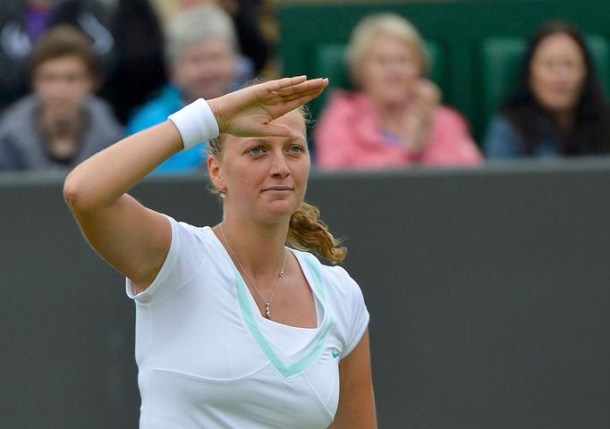 Česká tenistka Petra Kvitová zdraví diváky v utkání s Italkou Francescou Schiavoneovou během Wimbledonu 2012.