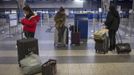 Travelers from South Korea use their mobile phones after arriving to an empty terminal as flights were cancelled at LaGuardia airport in New York October 28, 2012. Tens of millions of East Coast residents scrambled on Sunday to prepare for Hurricane Sandy, which could make landfall as the largest storm to hit the United States, bringing battering winds, flooding and even heavy snow. REUTERS/Adrees Latif (UNITES STATES - Tags: TRANSPORT DISASTER ENVIRONMENT TRAVEL)