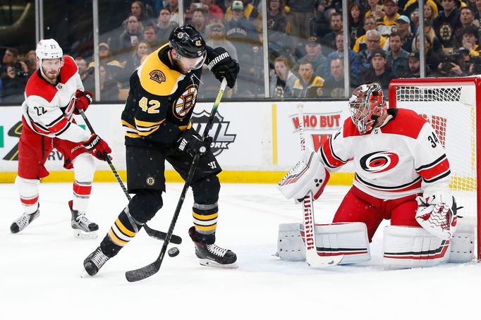 Petr Mrázek v brance Caroliny čelí ataku Davida Backese z Bostonu v prvním finále Východní konference NHL