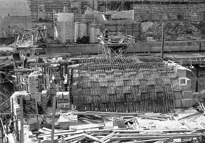 Historická fotografie zachycující výstavbu vodní nádrže Štěchovice, která probíhala mezi lety 1937 a 1944, navzdory válečným komplikacím.