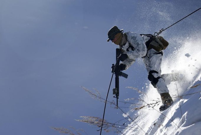 U.S. Marine Mark Stanich from Ohio, whose unit is based in Okinawa, rappels down during a winter military drill with South Korean marines in Pyeongchang, about 180 km (112 miles) east of Seoul February 7, 2013. North Korea has vowed to conduct more rocket and nuclear tests in response to a U.N. censure for its launch of a long-range missile launch in December. On Tuesday, it vowed "stronger" but unspecified actions in addition to the test. REUTERS/Lee Jae-Won (SOUTH KOREA - Tags: MILITARY) Published: Úno. 7, 2013, 9:45 dop.