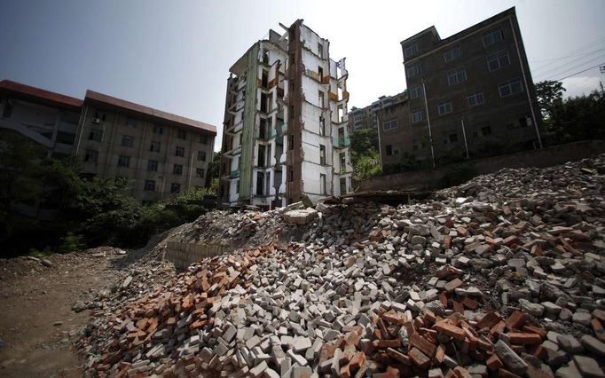 A building under demotion is seen at an residential area which will be relocated, in Huangtupo, Badong city, 100km (62 miles) from the Three Gorges dam in Hubei province in this August 8, 2012 file photo. China relocated 1.3 million people during the 17 years it took to complete the Three Gorges dam. Even after finishing the $59 billion project last month, the threat of landslides along the dam's banks will force tens of thousands to move again. It's a reminder of the social and environmental challenges that have dogged the world's largest hydroelectric project. While there has been little protest among residents who will be relocated a second time, the environmental fallout over other big investments in China has become a hot-button issue ahead of a leadership transition this year. Picture taken on August 8, 2012. To match story CHINA-THREEGORGES/ REUTERS/Carlos Barria/Files (CHINA - Tags: POLITICS ENVIRONMENT BUSINESS ENERGY) Published: Srp. 22, 2012, 8:35 odp.