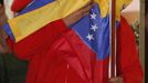 Venezuelan President Hugo Chavez hugs the national flag while celebrating from a balcony at the Miraflores Palace in Caracas October 7, 2012. Venezuela's socialist President Chavez won re-election in Sunday's vote with 54 percent of the ballot to beat opposition challenger Henrique Capriles. REUTERS/Jorge Silva (VENEZUELA - Tags: POLITICS ELECTIONS) Published: Říj. 8, 2012, 5:06 dop.