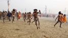 Naga sadhus, or Hindu holymen, run to attend the first 'Shahi Snan' (grand bath) at the ongoing "Kumbh Mela", or Pitcher Festival, in the northern Indian city of Allahabad January 14, 2013. During the festival, Hindus take part in a religious gathering on the banks of the river Ganges. "Kumbh Mela" will again return to Allahabad in 12 years. REUTERS/Ahmad Masood (INDIA - Tags: RELIGION SOCIETY) TEMPLATE OUT Published: Led. 14, 2013, 7:37 dop.