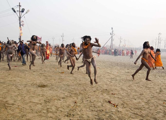 Naga sadhus, or Hindu holymen, run to attend the first 'Shahi Snan' (grand bath) at the ongoing "Kumbh Mela", or Pitcher Festival, in the northern Indian city of Allahabad January 14, 2013. During the festival, Hindus take part in a religious gathering on the banks of the river Ganges. "Kumbh Mela" will again return to Allahabad in 12 years. REUTERS/Ahmad Masood (INDIA - Tags: RELIGION SOCIETY) TEMPLATE OUT Published: Led. 14, 2013, 7:37 dop.