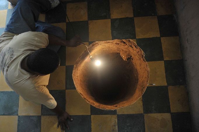 A man inspectas a sinkhole formed in a house on July 19, 2011 in the north of Guatemala City. When neighbors heard the loud boom overnight they thought a cooking gas canister had detonated. Instead they found a deep sinkhole the size of a large pot inside a home in a neighborhood just north of Guatemala City. The sinkhole was 12.2 meters (40 feet) deep and 80 centimeters (32 inches) in diameter, an AFP journalist who visited the site reported. Police, members of the country's natural disaster office and water utility company officials came to visit the site. Sinkholes, formed by the natural process of erosion, can be gradual but are often sudden. Guatemala City, built on volcanic deposits, is especially prone to sinkholes, often blamed on a leaky sewer system or on heavy rain.