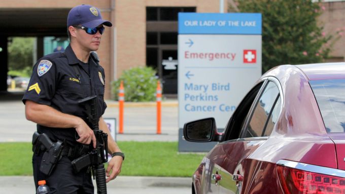 Ozbrojený policista střeží vstup do nemocnice po tragické střelbě v Baton Rouge.