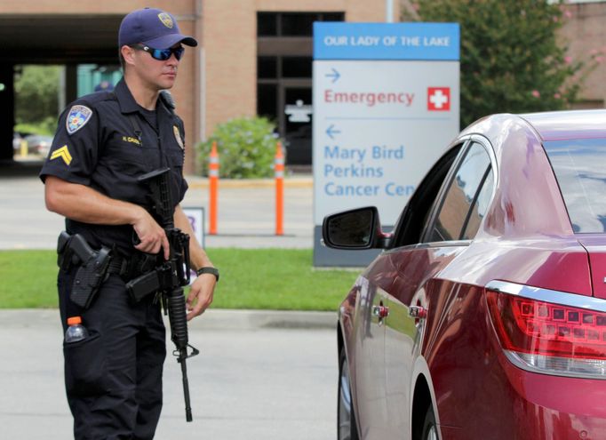 Ozbrojený policista střeží vstup do nemocnice po tragické střelbě v Baton Rouge.