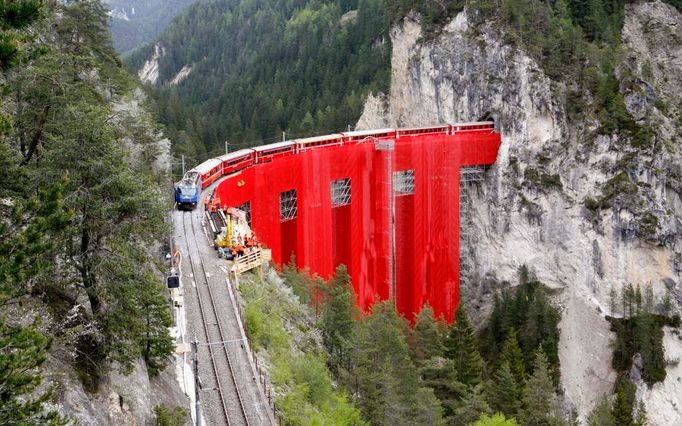 Rudá látka zakrývající lešení na opravované straně mostu Landwasserviadukt blízko švýcarského města Filisur, 12. května 2009. Most Landwasserviadukt coby součást železnice Rhaetian Railway a krajinné oblasti Albula/Bernina je pod ochranou UNESCA.