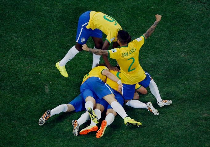 Brazil's players celebrate a goal by teammate Oscar (bottom, obscured) against Croatia during their 2014 World Cup opening match at the Corinthians arena in Sao Paulo Jun