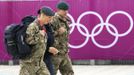 Members of the armed forces walk past the Olympic rings on the perimeter of the Olympic Park in Stratford, the location of the London 2012 Olympic Games, in east London July 15, 2012. The head of private security firm G4S said on Saturday his firm only realised just over a week ago it would not be able to supply enough venue guards for this month's London Olympics, as he publicly apologised for the embarrassing failure. On Thursday, the government said it would deploy additional troops after it became clear G4S was unlikely to provide the expected 10,400 guards it was contracted to do because of problems processing applicants. REUTERS/Andrew Winning (BRITAIN - Tags: MILITARY POLITICS SOCIETY SPORT OLYMPICS) Published: Čec. 15, 2012, 2:11 odp.