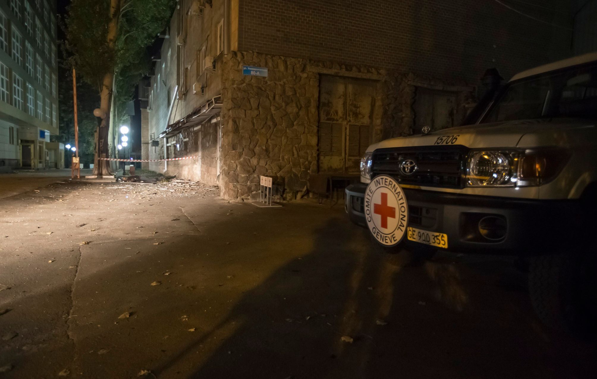 Auto Červeného kříže u zničené budovy MČK v Doněcku.