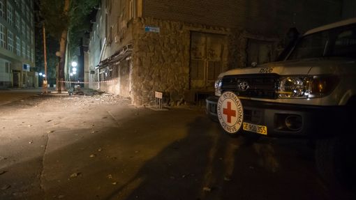Auto Červeného kříže u zničené budovy MČK v Doněcku.