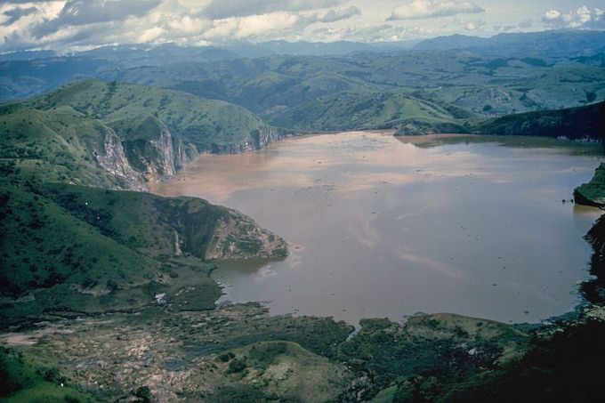 Jezero Nyos, Kamerun, srpen 1986. Letecký pohled po limnické erupci, která zbarvila vodu do rezavě hněda a usmrtila 1 746 lidí a tisíce zvířat.