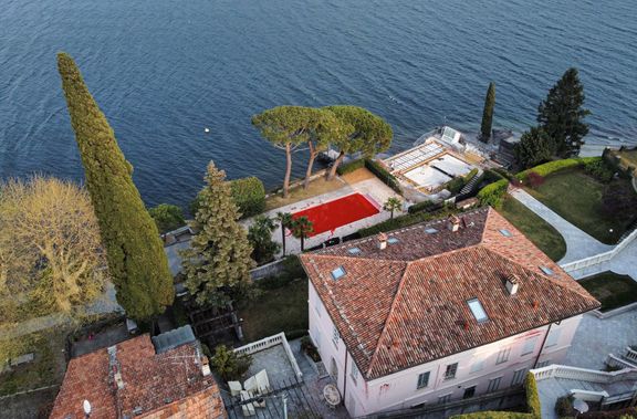 Solovjovova vila u italského jezera Como s rudými cákanci na omítce a vodou v bazéně zbarvenou do ruda.