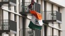 Men hang an Indian flag from a balcony in the Athletes' Village, ahead of the Olympic Games in the London 2012 Olympic Park at Stratford in London July 17, 2012. REUTERS/Luke MacGregor (BRITAIN - Tags: SPORT OLYMPICS) Published: Čec. 17, 2012, 5:33 odp.