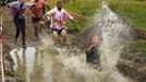 Zombies chase a runner (R) into a pool of water on the "Run for Your Lives" 5K obstacle course race in Amesbury, Massachusetts May 5, 2012. Runners face man-made and natural obstacles on the course, while being chased by zombies, who try to take "health" flags off the runners belts. REUTERS/Brian Snyder (UNITED STATES - Tags: SOCIETY) Published: Kvě. 5, 2012, 10:23 odp.