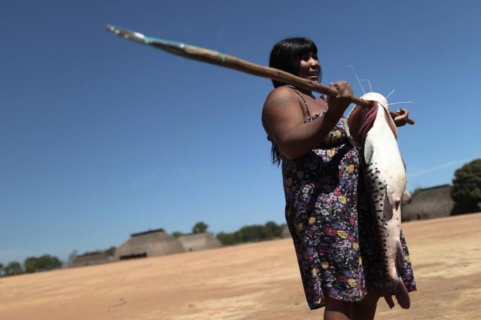 A Yawalapiti woman holds a fish that the tribe's men caught in the Tuatuari River while fishing to feed the guests of this year's 'quarup,' a ritual held over several days to honour in death a person of great importance to them, in the Xingu National Park, Mato Grosso State, August 15, 2012. This year the Yawalapiti tribe honoured two people - a Yawalapiti Indian who they consider a great leader, and Darcy Ribeiro, a well-known author, anthropologist and politician known for focusing on the relationship between native peoples and education in Brazil. Picture taken August 15, 2012. REUTERS/Ueslei Marcelino (BRAZIL - Tags: ANIMALS ENVIRONMENT SOCIETY) FOR EDITORIAL USE ONLY. NOT FOR SALE FOR MARKETING OR ADVERTISING CAMPAIGNS. ATTENTION EDITORS - PICTURE 02 OF 37 FOR THE PACKAGE 'THE YAWALAPITI QUARUP RITUAL' Published: Srp. 29, 2012, 10:20 dop.