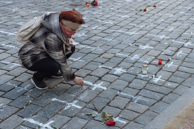 Lidé na Staroměstském náměstí v Praze spontánně uctívají oběti pandemie u křížů, které zde křídou nakreslila iniciativa Milion chvilek pro demokracii. 24 - 25. 3. 2021