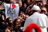 Věřící s tričkem "Milujeme papeže Františka" před bohoslužbou na Svatopetrském náměstí ve Vatikánu. Požehnání Městu a světu papež pronesl pouze italsky. Nenavázal tak na tradici zavedenou svými předchůdci, kteří zdravili věřící v desítkách jazyků.