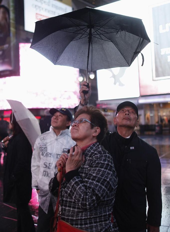 People keep under an umbrella in the mostly deserted Times Square ahead of Hurricane Sandy in New York October 29, 2012. Hurricane Sandy is shaping up to be one of the biggest storms ever to hit the United States but even with the severe damage that is expected, the blow to the economy is seen as short-term. REUTERS/Carlo Allegri (UNITED STATES - Tags: SOCIETY ENVIRONMENT DISASTER) Published: Říj. 30, 2012, 1:38 dop.